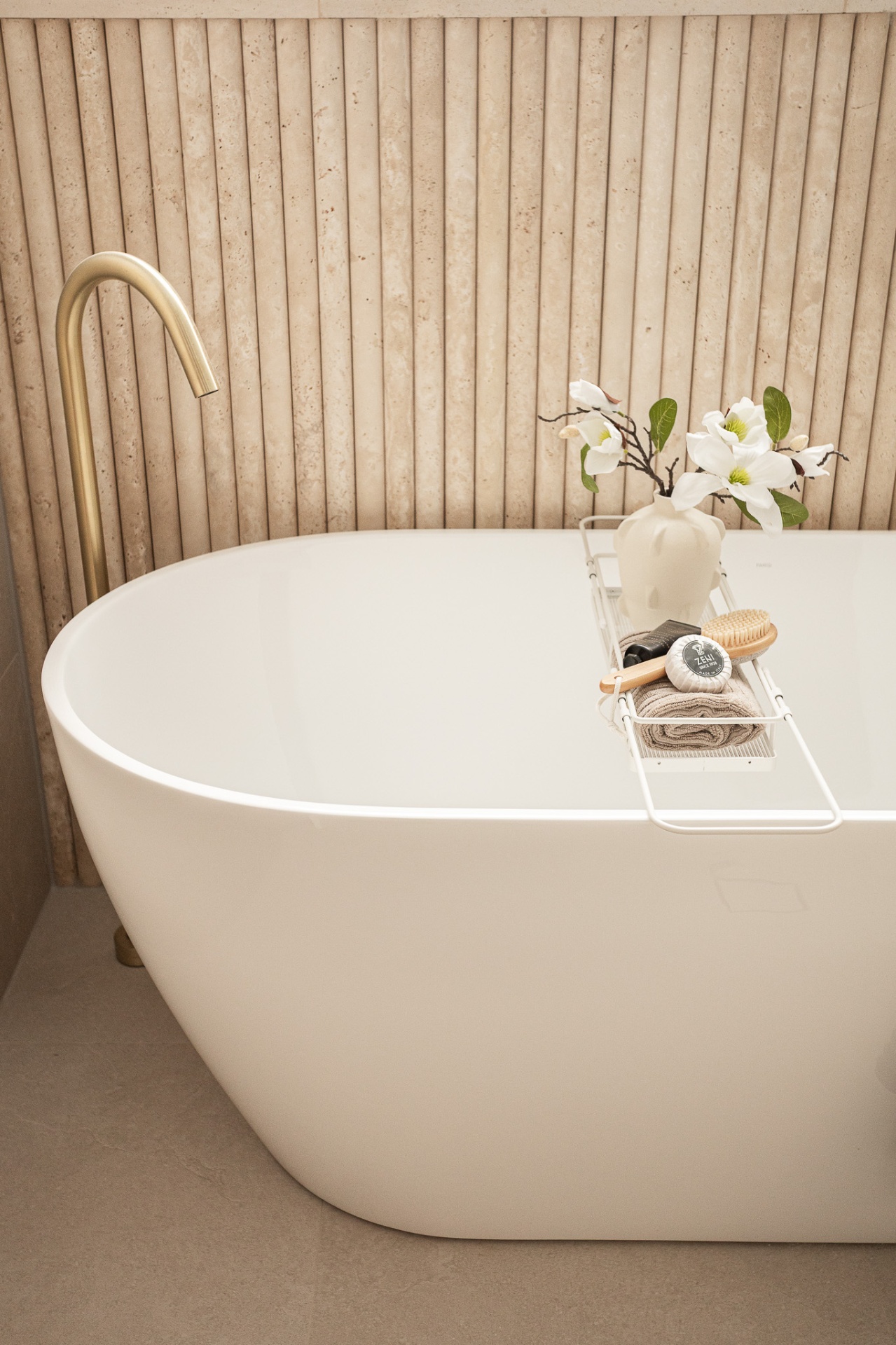 Freestanding stone bath with brushed brass tapware